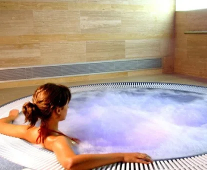 Mujer disfrutando del jacuzzi del centro de spa del hotel.