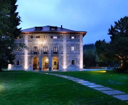 Edificio con iluminación nocturna con amplios jardines de este hotel boutique.