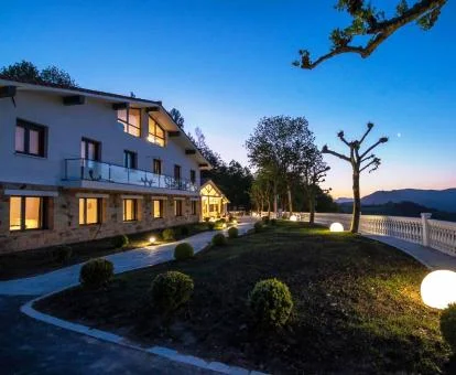 Edificio con iluminación nocturna y bellos jardines de este coqueto hotel.