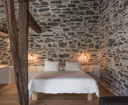 Preciosa habitación con paredes de piedra a la vista de este acogedor hotel boutique rural.