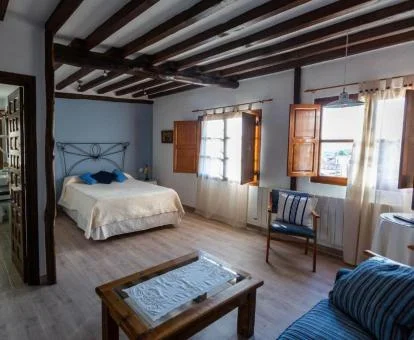 Una de las coquetas habitaciones de estilo rústico con zona de estar de este hotel acogedor.