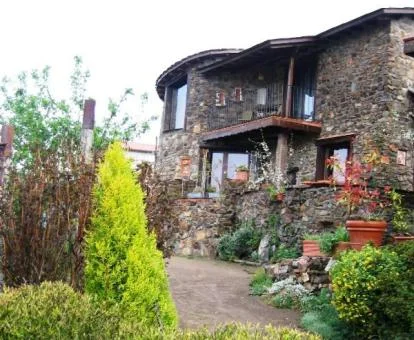 Edificio de este hotel rural rodeado de vegetación con zona exterior.