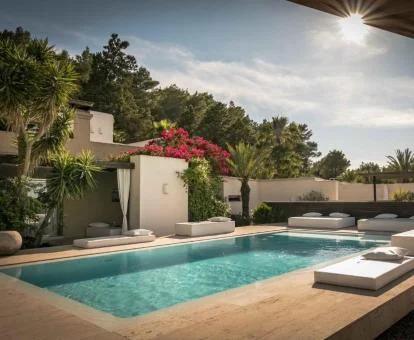 Hermosa piscina exterior de este hotel rodeado de vegetación.