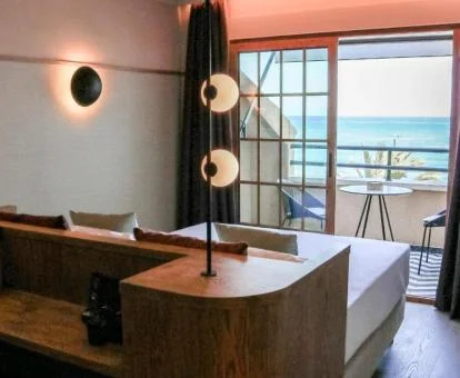 Una de las modernas habitaciones con terraza amueblada y vistas al mar del hotel.