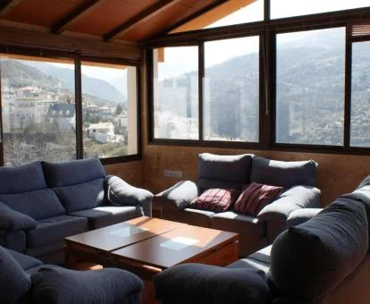 Espacio de uso compartido con amplios ventanales y vistas al campo de este hotel rural.