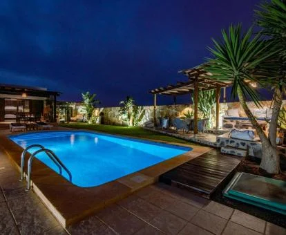 Terraza con mobiliario exterior y piscina al aire libre de este hotel solo para adultos con iluminación nocturna.