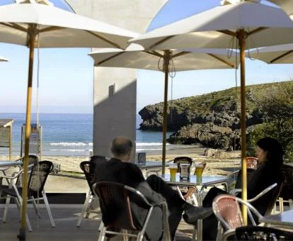 Personas disfrutando del comedor con vistas al mar de este hotel con encanto.