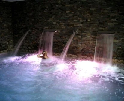 Una persona disfrutando de la zona de aguas del spa.