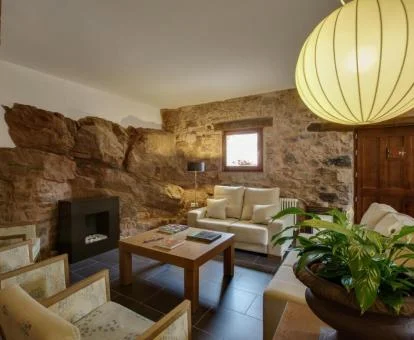 Agradable espacio de uso compartido con sofás y chimenea de esta posada rural.