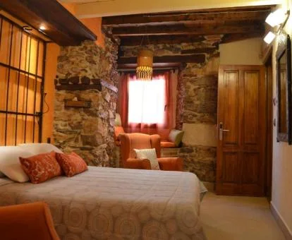 Una de las habitaciones rústicas con paredes de piedra a la vista del hotel.