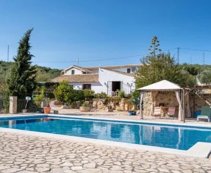 Hotel con encanto rodeado de jardines y amplia piscina al aire libre.