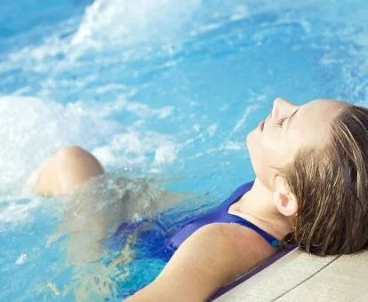 Mujer disfrutando de la zona de aguas del spa.