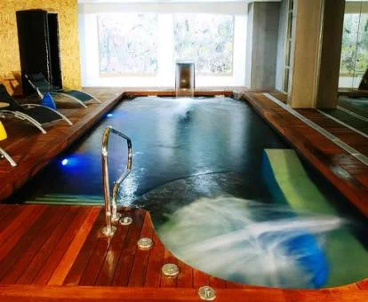 Piscina cubierta con hidroterapia y zona de relajación del centro de bienestar del hotel.