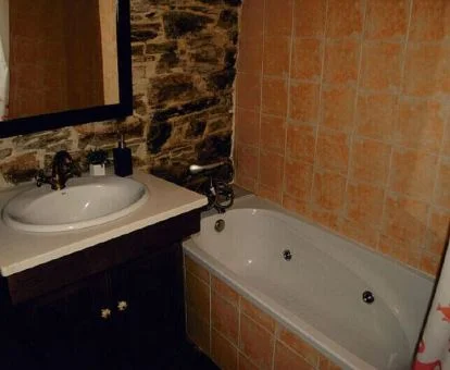 Bañera de hidromasaje en el baño de este apartamento rural.