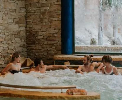 Varias personas disfrutando de la zona de aguas del spa.