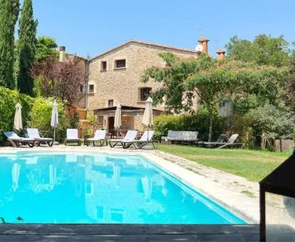 Acogedor hotel con amplios jardines con mobiliario y piscina exterior.