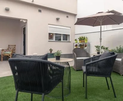 Terraza ajardinada con mobiliario al aire libre de este hotel solo para adultos.