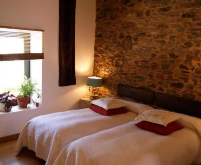 Acogedora habitación con paredes de piedra a la vista de este hotel boutique rural.