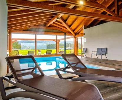 Zona de bienestar con piscina cubierta y vistas a la naturaleza de este complejo de apartamentos.