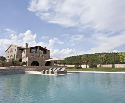 Hotel con encanto rodeado de jardines con una gran piscina al aire libre.