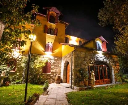 Edificio de este hotel solo para adultos con jardín e iluminación nocturna.