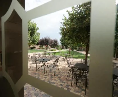 Bello patio ajardinado con comedores exteriores de este hotel boutique.