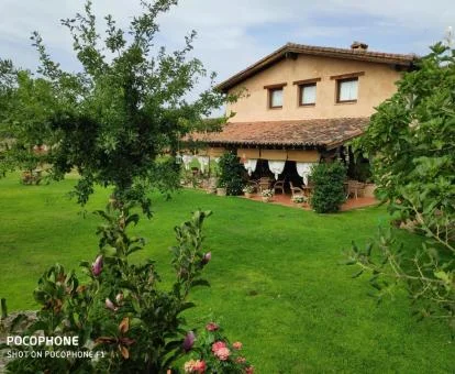 Hotel rural con amplios jardines y vegetación.