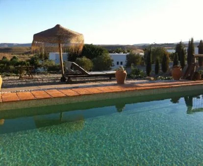 Zona exterior con piscina y vistas al campo que rodea el hotel.