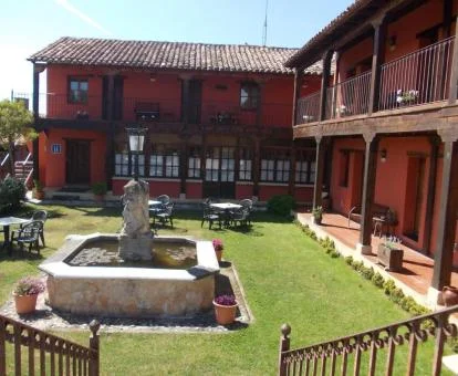 Edificio de este alojamiento rural con zona exterior ajardinada y mobiliario.