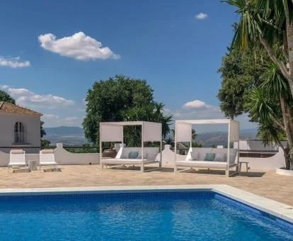 Zona exterior con piscina y solarium con vistas de este establecimiento rural.