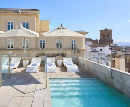 Amplia terraza con tumbonas y piscina al aire libre de este hotel con encanto.