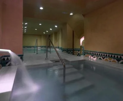 Piscina cubierta con elementos de hidroterapia del spa del hotel.