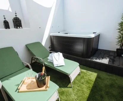 Terraza privada con tumbonas y un gran jacuzzi al aire libre de este coqueto apartamento.