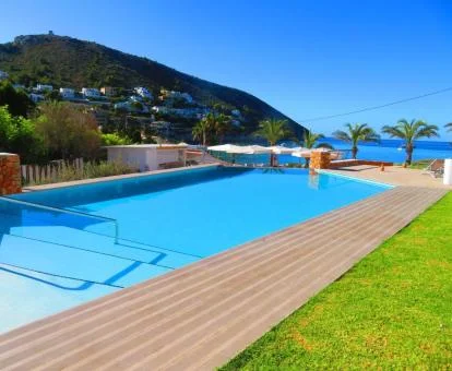 Amplia zona exterior con piscina y vistas al mar del hotel.