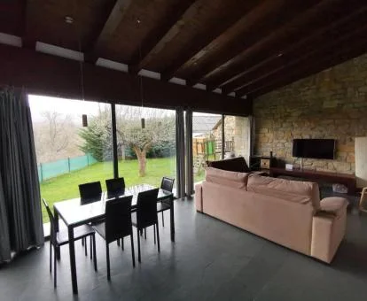 Sala de estar con amplios ventanales y vistas al jardín de esta casa independiente.