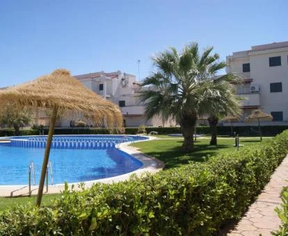 Complejo de apartamentos con grandes jardines y piscina al aire libre.