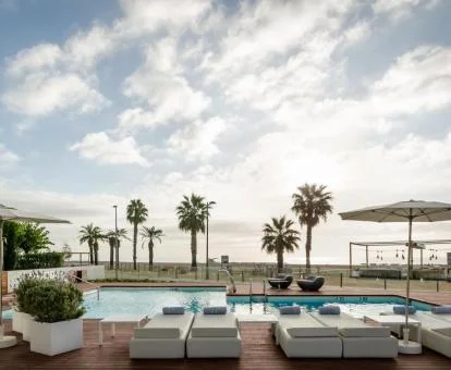 Zona exterior de este hotel con piscinas y cómodas tumbonas con acceso directo a la playa.