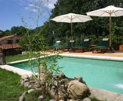 Piscina exterior rodeada de jardines de este acogedor hotel rural.