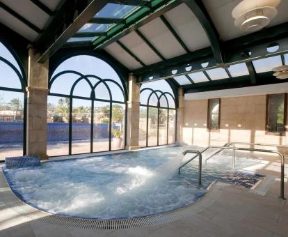 Preciosa piscina cubierta con hidroterapia del spa del hotel.