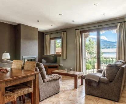 Interior de uno de los preciosos apartamentos con amplios ventanales y balcón con espectaculares vistas a la naturaleza de este complejo.