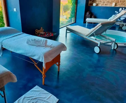 Sala de bienestar del hotel con zona de aguas y camillas para masajes con vistas al exterior.