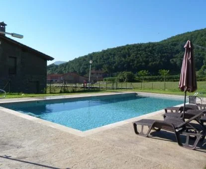 Amplia piscina exterior rodeada de jardines y tumbonas de este precioso hotel rural.