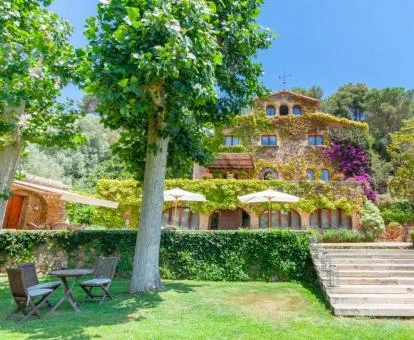 Preciosa fachada de este hotel rural rodeado de jardines. Fachada con vegetación colorida de este precioso hotel con amplios jardines y zonas de estar exteriores.