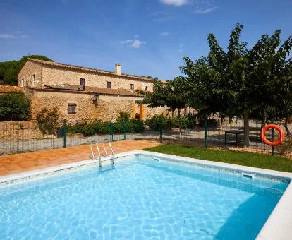 Edificio de este hotel rural con amplia piscina y jardines.