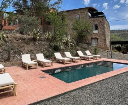 Edificio de este precioso hotel rural con piscina y tumbonas.