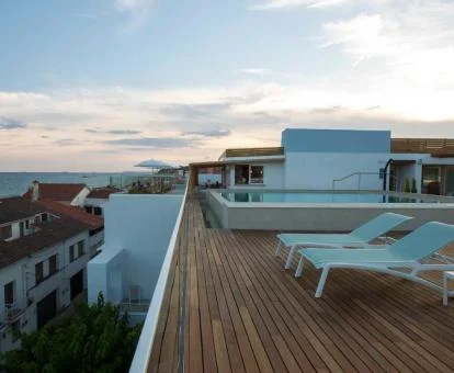 Terraza solarium con piscina y vistas al mar del hotel.