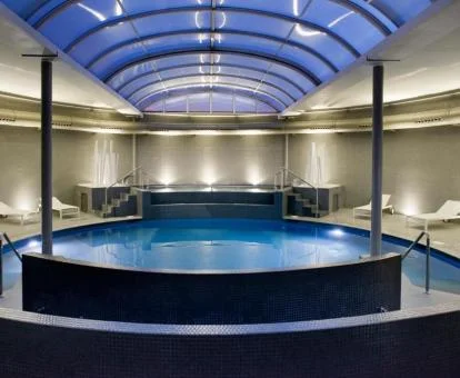 Piscina cubierta con elementos de hidroterapia del spa del hotel.