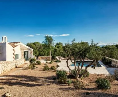 Hotel con encanto rodeado de vegetación con piscina exterior.