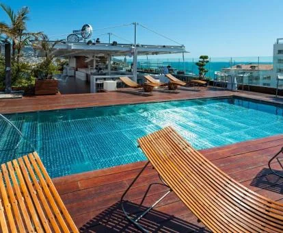 Amplia piscina y zonas exteriores de este hotel romántico con vistas al mar.