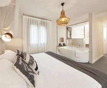 Amplio dormitorio con jacuzzi privado cerca de la cama de uno de los apartamentos del establecimiento.